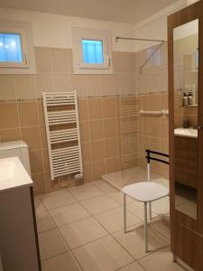 ein Bad mit einer Dusche und einem Stuhl in der Unterkunft Maison au calme avec jardin et local vélo in Jonquières