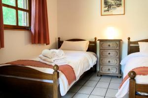 Un dormitorio con dos camas con toallas y una cómoda. en Hotel Sunshine Balatonlelle, en Balatonlelle