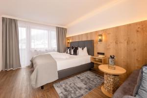 a hotel room with a bed and a couch at Hotel Alphof Stubaital in Fulpmes