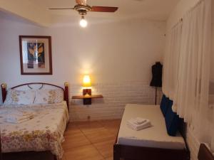 a bedroom with a bed and a table and a lamp at Cantinho da Vovó Regina in Miguel Pereira +51 photos
