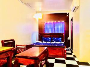 a room with a bed and two tables and chairs at Sihariddh Guesthouse in Siem Reap +14 photos