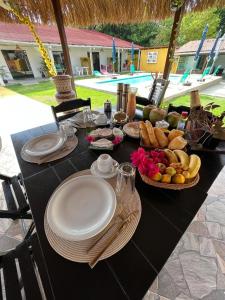 ein schwarzer Tisch mit Teller mit Lebensmitteln drauf in der Unterkunft Pousada Reloday in Salvaterra