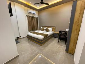 una camera con letto, tavolo e sedia di HOTEL THE GRAND MARUTI a Junagadh