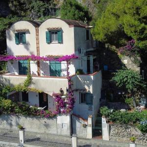 una casa con flores al lado de una colina en Casa Vacanze Bouganvillea, en Cetara