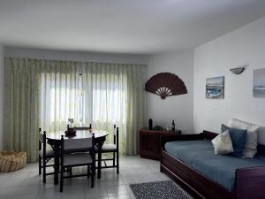 a bedroom with a table and a bed and a dining room at Caparica Ocean View in Costa da Caparica