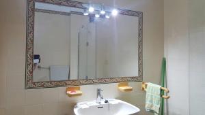 y baño con lavabo y espejo. en Caparica Ocean View, en Costa da Caparica