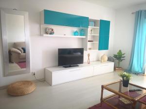 una sala de estar con TV en un armario blanco en Caparica Ocean View, en Costa da Caparica