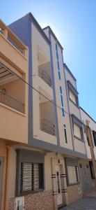 a building with blue trim and balconies on it at Appart Clim Wifi 700m de la Plage in Saïdia
