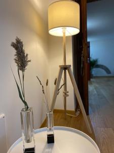 a table with two vases and a lamp on it at ORVIETO ANTICA Apartment in Orvieto