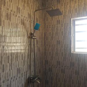 um chuveiro na casa de banho com uma cabeça de chuveiro em SURPRISE PALACE em Ibadan