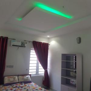 uma luz verde no tecto de um quarto em SURPRISE PALACE em Ibadan