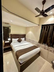 una camera con letto e ventilatore a soffitto di KALPANA RESIDENCY - Near US Embassy a Mumbai
