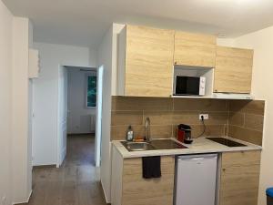 a kitchen with a sink and a microwave at Appartement lumineux près métro in Saint-Denis