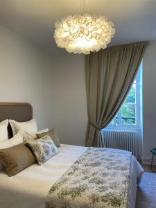 um quarto com uma cama grande e um lustre em Richard Lequet Domaine gastronomique du Val d Atur em Boulazac