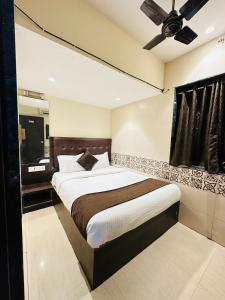 Schlafzimmer mit einem großen Bett und einem Deckenventilator in der Unterkunft KALPANA RESIDENCY - Near US Embassy in Mumbai