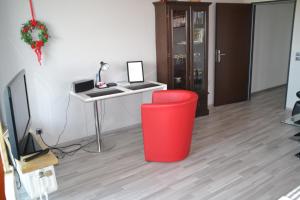 Zimmer mit einem Schreibtisch und einem roten Mülleimer in der Unterkunft Ferienwohnung Am Steinberg in Hildesheim
