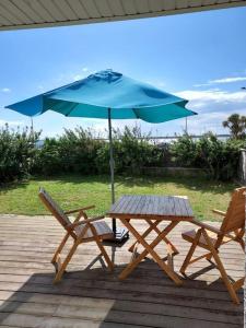 une table de pique-nique et un parasol sur une terrasse dans l'établissement le petit suroit, à Carnac