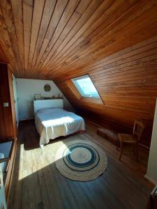 - une chambre avec un lit et un plafond en bois dans l'établissement le petit suroit, à Carnac