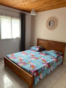 ein Schlafzimmer mit einem Bett mit einer Decke darauf in der Unterkunft Ti kaz peruches in Saint-Pierre