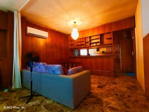 a living room with a blue couch in a room at 爱心小屋 温馨如家 in Piraeus