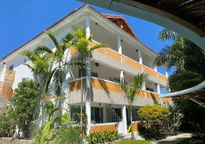 un grand bâtiment blanc avec des palmiers devant lui dans l'établissement Bahia Residence Cabarete, à Cabarete