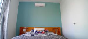 ein Schlafzimmer mit einem Bett mit einer blauen Wand in der Unterkunft Vista Funchal in Funchal