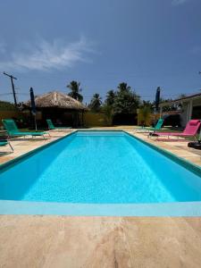 uma grande piscina azul com cadeiras e uma casa em Pousada Reloday em Salvaterra