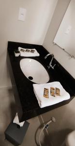 a bathroom with a black counter with a sink at Pousada Estrela de Davi in Penha
