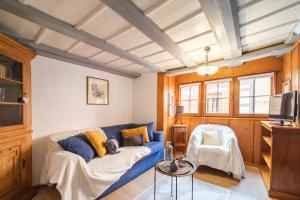 uma sala de estar com um sofá azul e uma cadeira em L Oriel du Rempart Nord em Eguisheim