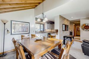 Una cocina y un comedor con mesa y sillas de madera. en Meadow House, Unit 31, en Sunriver