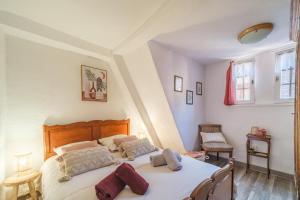 a bedroom with a large white bed in a room at L Oriel du Rempart Nord in Eguisheim