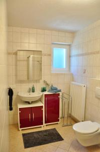 Apartment Aste في Aldrans: حمام مع حوض ومرحاض ومرآة