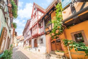 an alley in an old town with buildings at L Oriel du Rempart Nord in Eguisheim