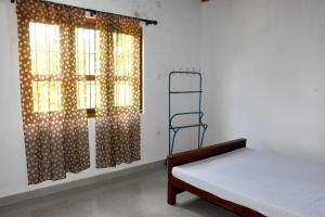 - une chambre avec un lit et une fenêtre avec une échelle dans l'établissement Camellia Resort, à Anurâdhapura