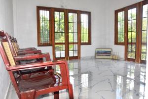 Cette chambre dispose de chaises, de fenêtres et d'un sol en marbre. dans l'établissement Camellia Resort, à Anurâdhapura