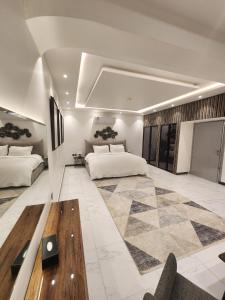 Cette grande chambre comprend 2 lits et une table en bois. dans l'établissement ريفان لبيوت الضيافة خاصة, à Yanbu