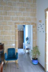 a living room with a blue chair and a brick wall at B&B Charming House in Salerno