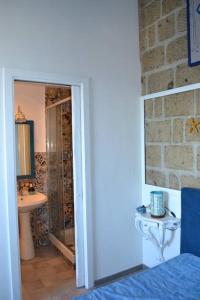 una camera da letto con bagno dotato di lavandino e specchio di B&B Charming House a Salerno