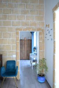 uma sala de estar com uma cadeira azul e uma parede de tijolos em B&B Charming House em Salerno