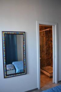 uno specchio a parete accanto alla camera da letto di B&B Charming House a Salerno