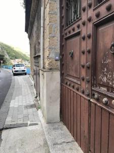 een gebouw met een grote houten deur aan de straatkant bij B&B Charming House in Salerno