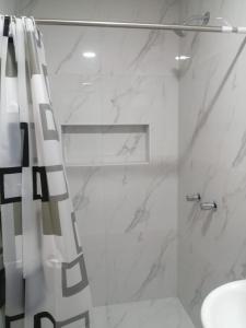 y baño con ducha y cortina de ducha. en Apartamentos Cristo Rey., en Tacna