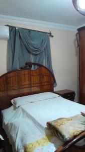 1 dormitorio con 1 cama con cabecero de madera en القاهرة en El Cairo