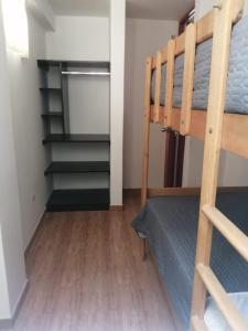 ein Schlafzimmer mit einem Etagenbett und einem Schrank in der Unterkunft Apartamentos Cristo Rey. in Tacna