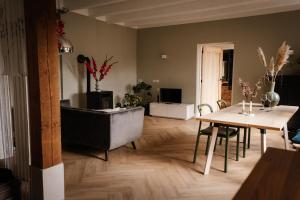 - un salon avec une table et un canapé dans l'établissement Heeren van Acquoy, à Acquoy