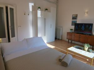 sypialnia z białym łóżkiem i telewizorem w obiekcie MILAN stilysh apartment near Metro and Fiera MICO w Mediolanie