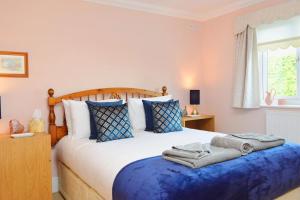 a bedroom with a large bed with a blue blanket at Sandy Gem - Viking Bay Getaway in Kent