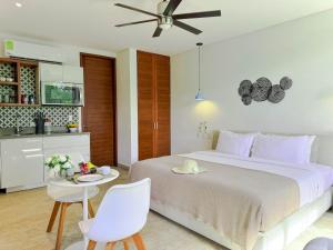 a bedroom with a bed and a table and a kitchen at Increíble estudio G204 con gimnasio incluido by Sandy Powerful in Tulum +28 photos