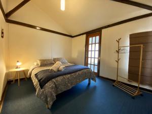 a bedroom with a large bed with a blue carpet at Kawi Hostel in Puerto Natales