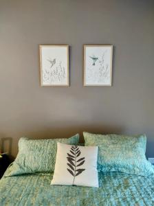 ein Schlafzimmer mit zwei Bildern an der Wand über einem Bett in der Unterkunft Apartamento estudio Flor de Lis in Salta